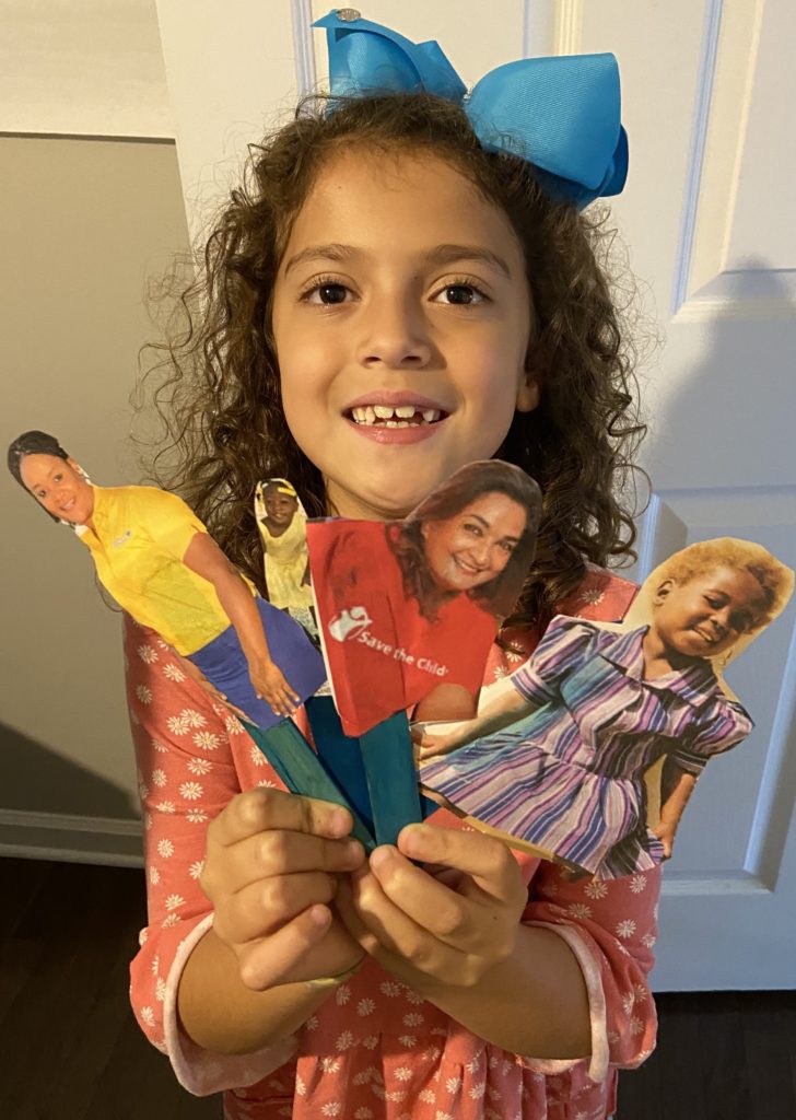 Young Child holding up popsicle stick puppets